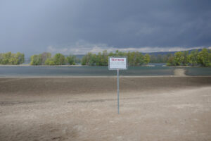 Warschild am unbewachten Flußbadestrand